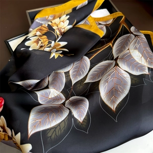 Macro detail of luxury floral print on silk scarf with elegant gold and silver patterns