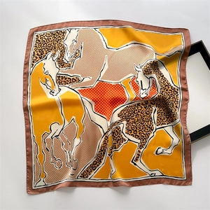 Detail of silk square scarf featuring horse motif, leopard print and smooth texture