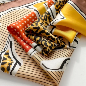 Macro shot of faux silk scarf featuring leopard print, red polka dots and yellow accents