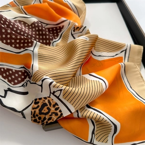 Close-up of leopard and horse print silk scarf with orange geometric patterns