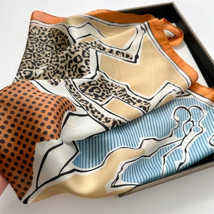Detailed view of the leopard print and polka dot patterns on a smooth satin square scarf