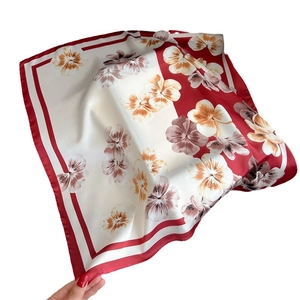 Floral print square silk scarf with red border showing elegant drape and smooth texture
