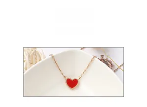 Dettaglio della collana con ciondolo a cuore rosso con bordo perlato e finitura oro 18K