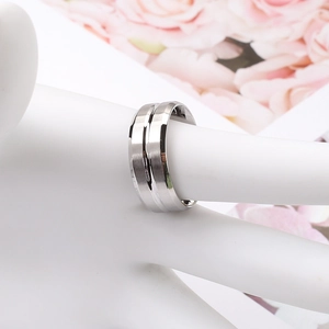 Detail of minimalist titanium steel ring featuring a silver brushed texture and central groove
