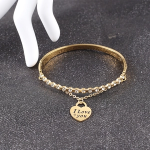 Detail of gold stainless steel bangle with I Love You heart charm and rhinestones