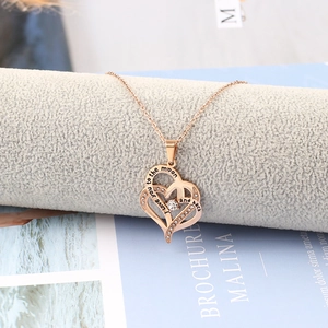 Dettaglio della collana a doppio cuore in oro rosa con cristalli e incisione romantica