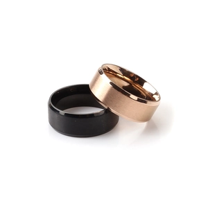 Detail of matte black and rose gold brushed stainless steel couple rings with polished inner