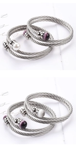 Makro-Detail von mehrsträngigem geflochtenem Edelstahl-Kabelarmband mit Perlenakzenten