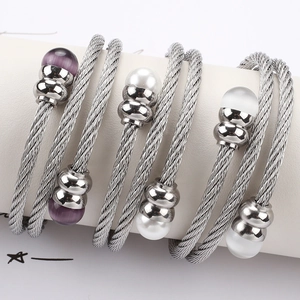 Detailansicht der dreifachen Edelstahl-Kabelarmbänder mit Perlen- und Opal-Inlay