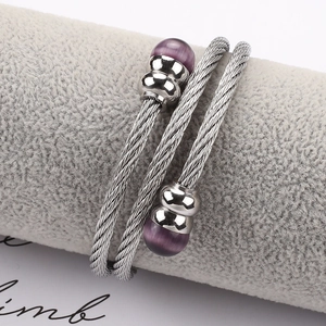 Nahaufnahme eines gedrehten Edelstahl-Kabelarmbands mit lila Perlen auf der Anzeige