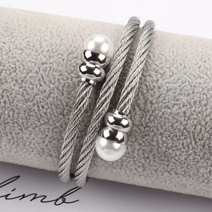 Detail eines silbernen Edelstahl-Kabelarmbands mit eleganten weißen Doppelperlen
