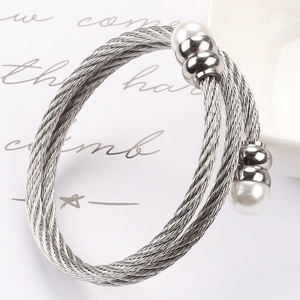 Detailansicht eines silbernen gedrehten Kabelarmbandes mit eleganten Perlen und Perlen