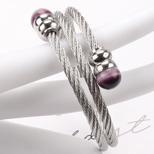 Details von silbernem Edelstahl-Kabelarmband mit runden lila Perlen im Detail