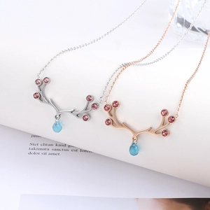 Detail view of elk antler necklaces with blue teardrop pendants and pink zircons