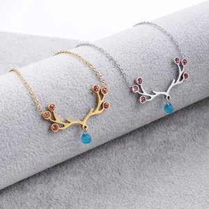Detail of elk antler necklaces with pink and blue gemstones in gold and silver finishes