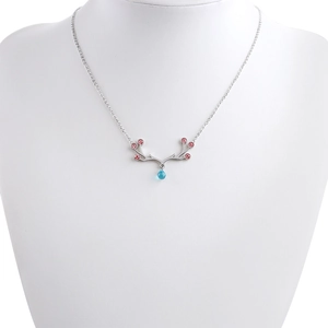 Detail of silver elk antler necklace with pink stones and blue teardrop gem on neck model