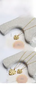 Detail showing small and large gold-toned heart pendants with unique hammered texture