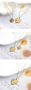 Detail of gold heart pendant with unique hammered texture on a dainty link chain