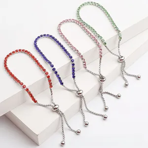 Dettaglio di quattro bracciali regolabili con zirconi in rosso, blu, rosa e verde