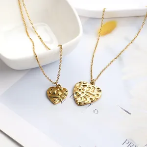 Detail of gold heart pendant necklace featuring hammered texture and delicate thin chain