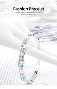 Detail of silver stainless steel bangle with square blue stones and double pavé rhinestones