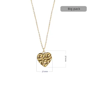 Detail of 21mm gold heart pendant with hammered texture on a minimalist steel chain