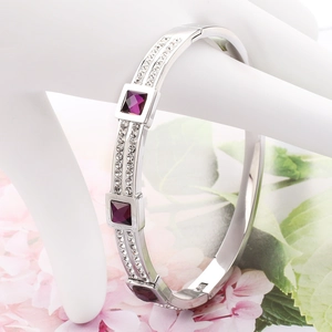 Detail of silver stainless steel bangle featuring square purple stones and clear rhinestones