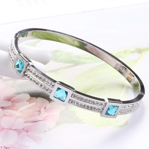 Detailed close-up of a silver steel bracelet with blue square crystals and pave accents