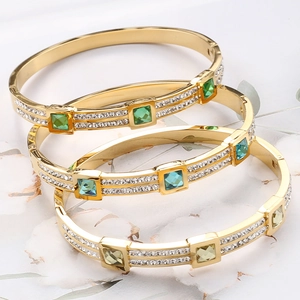 Detail of square gemstones in emerald, blue, and champagne on crystal-paved bangles