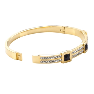 Detail of gold-plated bangle featuring black square gemstones and paved white zircons