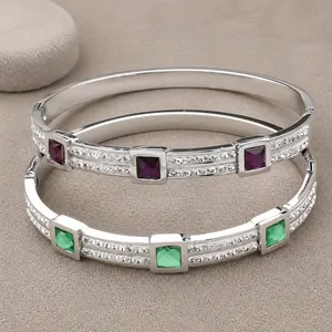 Macro shot of silver titanium steel bangles with purple and green square gemstones