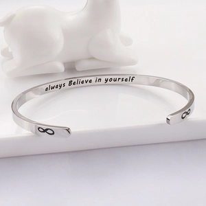 Macro detail of silver stainless steel cuff engraved with always Believe in yourself