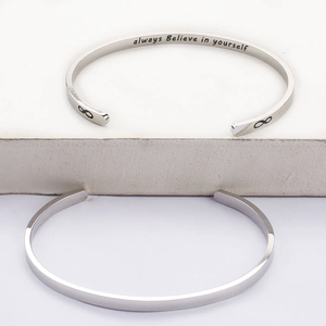 Detailed macro view of silver stainless steel cuff bracelet with always believe in yourself engraving