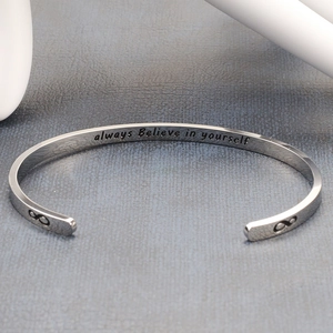 Detailed macro view of an open cuff bracelet with Always Believe in Yourself engraving