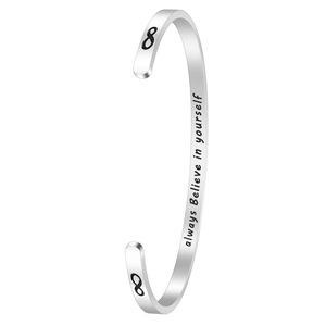 Detail of silver C-shape cuff bracelet featuring infinity symbols and inspirational engraving