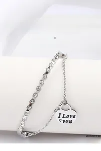Macro shot of silver stainless steel bangle with rhinestones and heart love charm