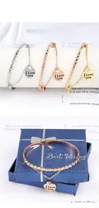 Detailed view of heart charm bangles in gold, silver, and rose gold with crystal accents
