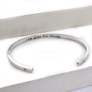 Detailed view of silver cuff bracelet with I Am With You Always engraving and hearts