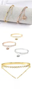 Detail of a double-layer stainless steel bracelet with heart pendant and cubic zirconia