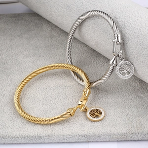 Detailed macro view of cable twist bangles with crystal-embedded Tree of Life charms