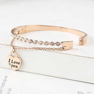 Detail of rose gold bangle with heart charm, crystals and I Love You engraving