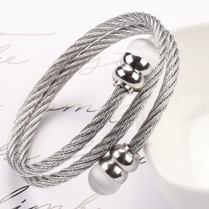 Detail eines Edelstahl-Kabelarmbands mit weißen Opalperlen auf einer weißen Schüssel