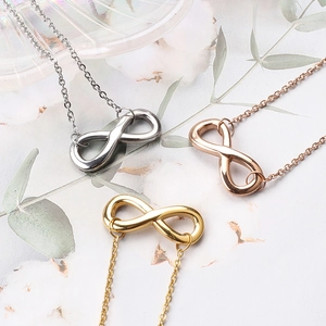 Infinity symbol anklets in silver, rose gold and gold finishes on a floral background