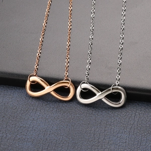 Detailed view of infinity symbol anklets in rose gold and silver finishes on dark background
