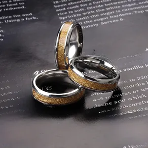 Detail of stacked two-tone stainless steel rings with gold brushed center and silver edges