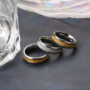 Macro detail of 18k gold and silver stainless steel rings with meteorite texture