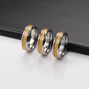 Polished silver stainless steel rings with gold foil texture inlay on black and white background