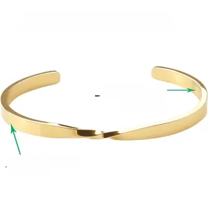 Detail view of gold Mobius twist bangle showing custom engraving service on the inner band