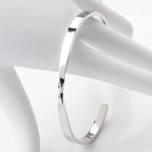 Polished silver Mobius twist cuff bracelet displayed on a white hand model