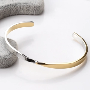 Detail of twisted Mobius bracelet featuring two-tone gold and silver stainless steel